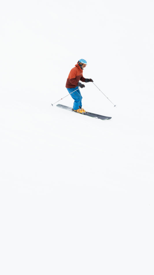 a man riding skis down a snow covered slope