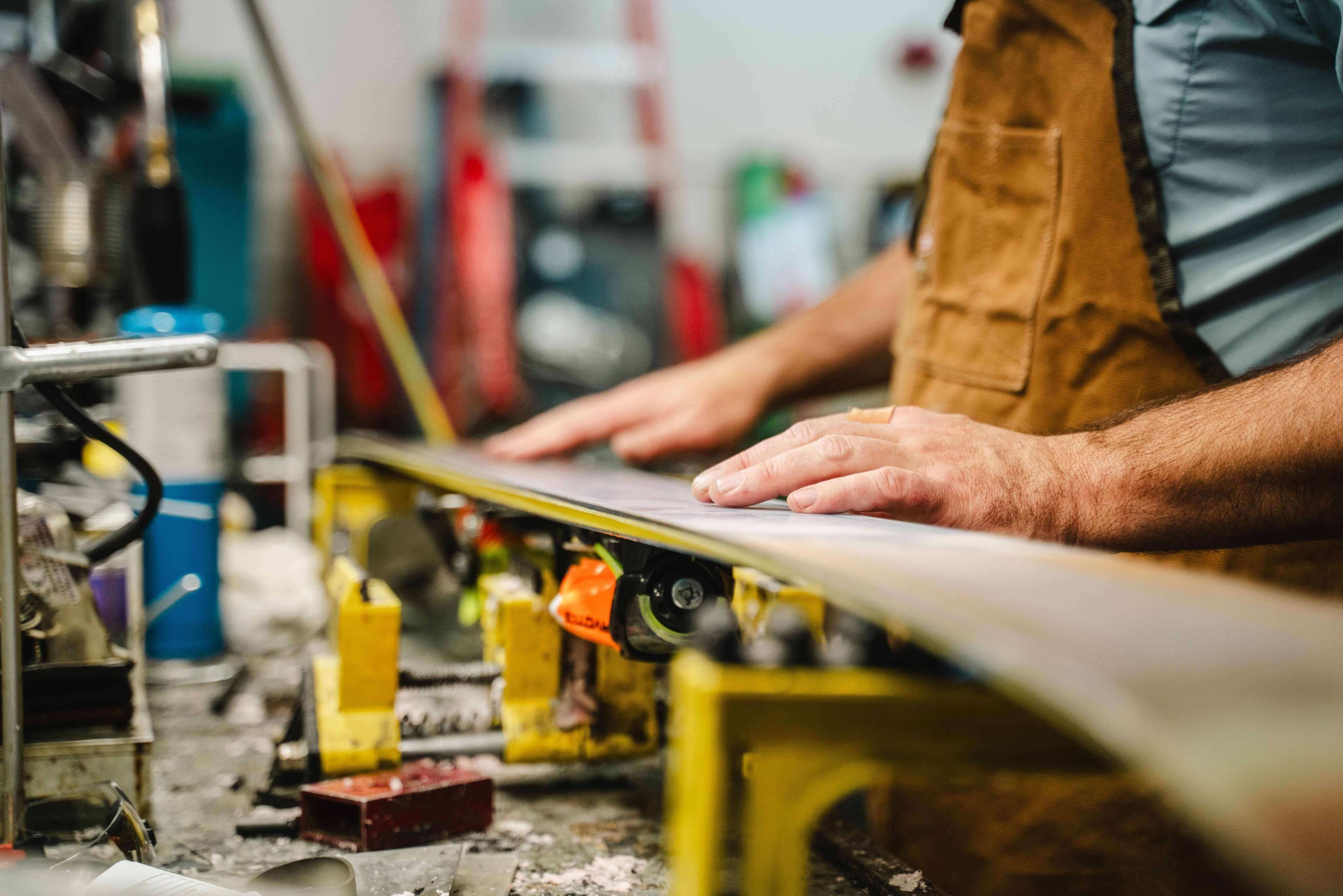Skis being professionally tuned in a workshop, highlighting ski maintenance and performance preparation.