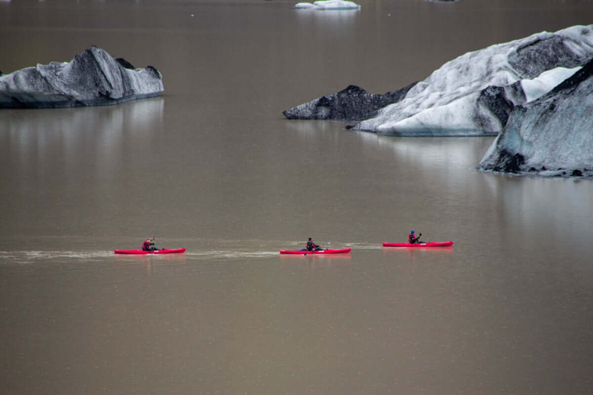 a group of people in kayaks on a beach
