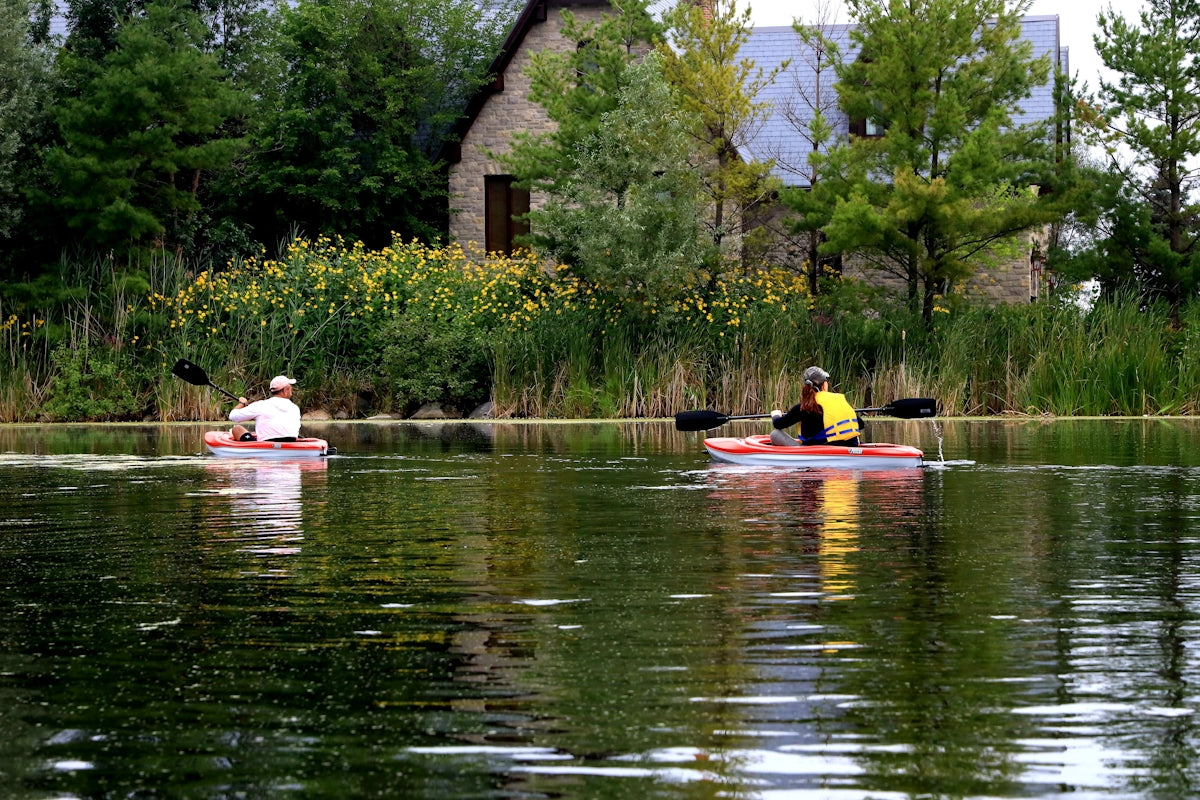 man and woman riding on red and yellow kayak on river during daytime