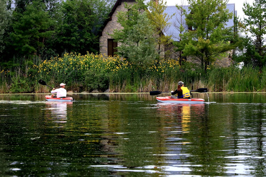 man and woman riding on red and yellow kayak on river during daytime