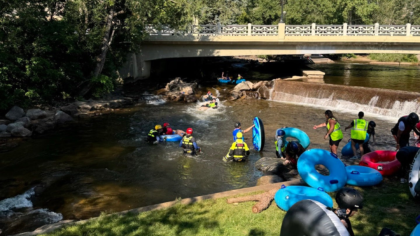 Group launching tubes into Boulder Creek with helmets and life jackets